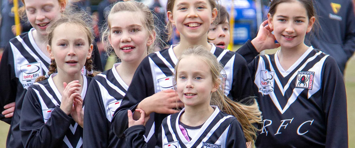 Ringwood Redbacks junior girls team in club jumpers gathered on the field